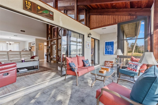 living room with a notable chandelier, a wealth of natural light, high vaulted ceiling, and wooden ceiling