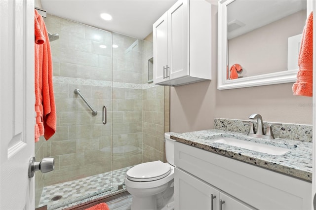 bathroom featuring vanity, walk in shower, and toilet