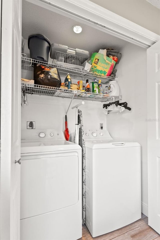 laundry room featuring washer and dryer and light wood-type flooring