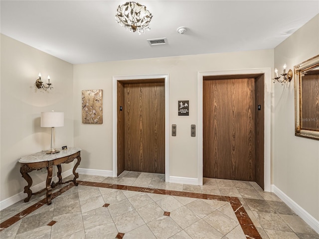 entryway with elevator, visible vents, and baseboards