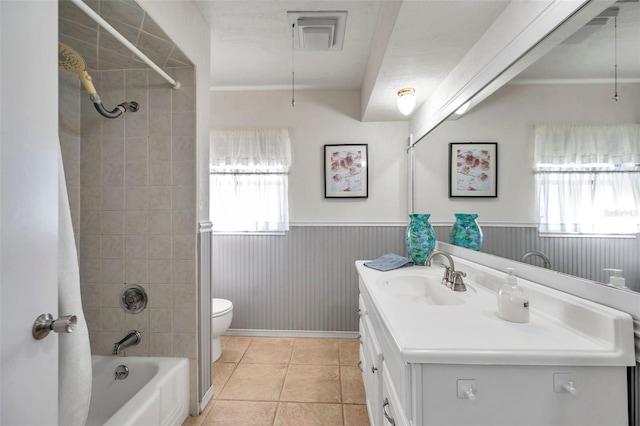 full bathroom with tile patterned floors, vanity, toilet, and tiled shower / bath combo