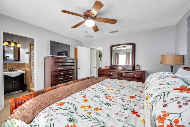 bedroom featuring ceiling fan, ensuite bath, and sink