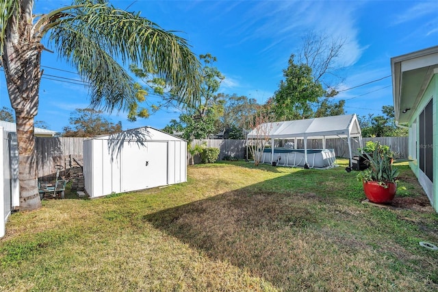 view of yard with a fenced in pool and a storage shed