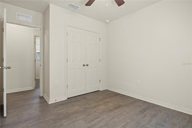 unfurnished bedroom with ceiling fan, dark hardwood / wood-style floors, and a closet