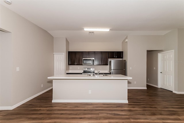 kitchen featuring dark brown cabinetry, sink, a center island with sink, and appliances with stainless steel finishes