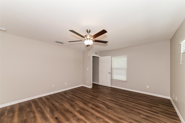 empty room with ceiling fan and dark hardwood / wood-style flooring