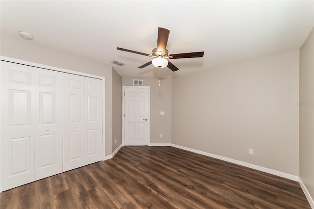 unfurnished bedroom with dark hardwood / wood-style floors, ceiling fan, and a closet