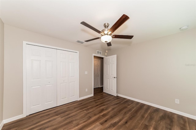 unfurnished bedroom with ceiling fan, dark hardwood / wood-style floors, and a closet