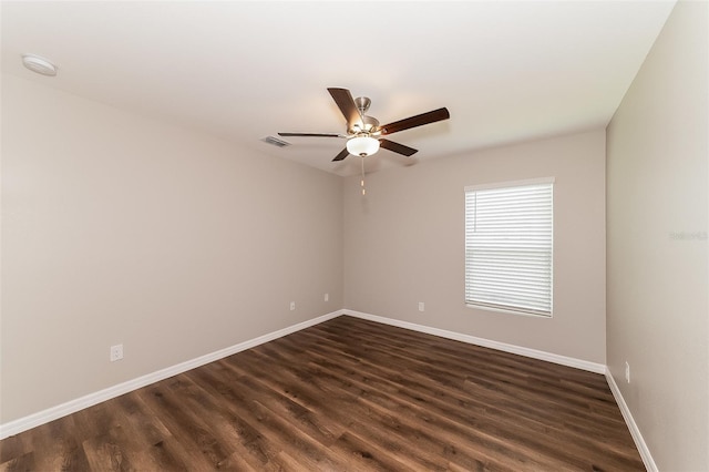 spare room with dark hardwood / wood-style flooring and ceiling fan