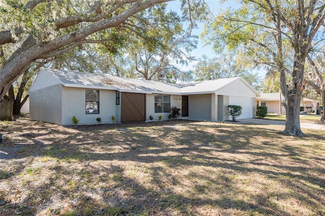 single story home featuring a garage and a front yard