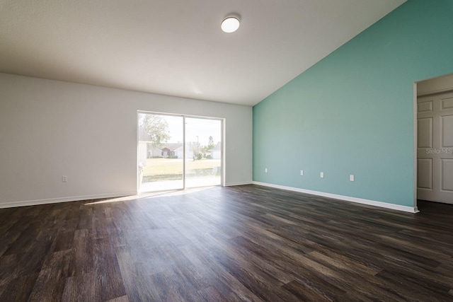 unfurnished room featuring lofted ceiling and dark hardwood / wood-style flooring