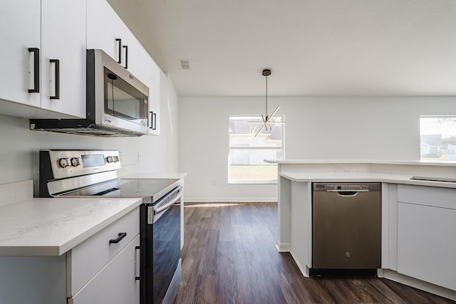 kitchen featuring white cabinetry, appliances with stainless steel finishes, hanging light fixtures, and plenty of natural light