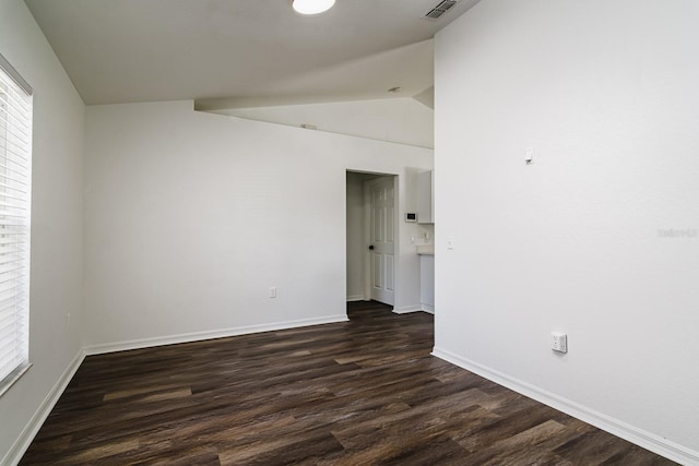 empty room featuring lofted ceiling and dark wood-type flooring