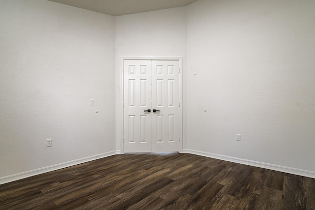 empty room with dark hardwood / wood-style flooring