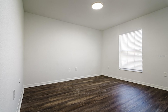 spare room with dark hardwood / wood-style flooring and plenty of natural light