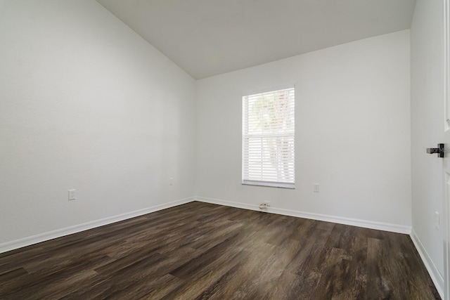 unfurnished room featuring vaulted ceiling and dark hardwood / wood-style floors