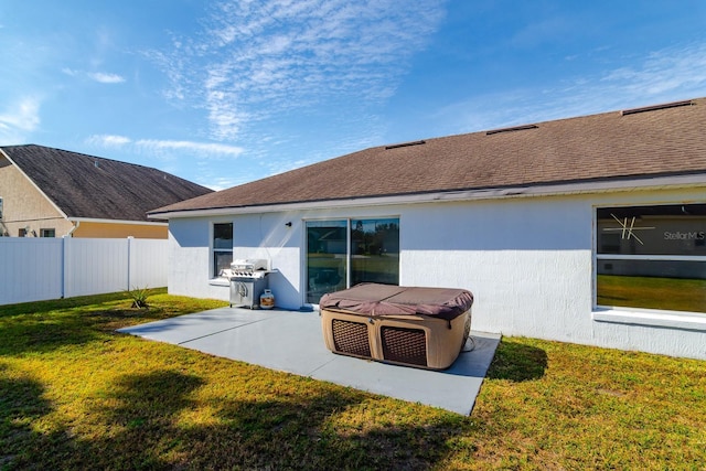 back of property with a lawn and a patio