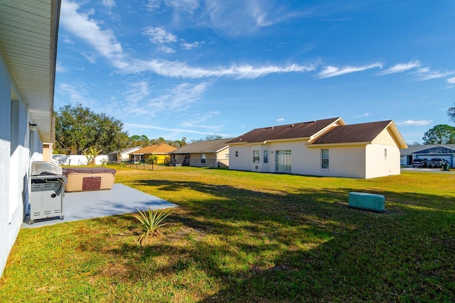 view of yard with a hot tub and a patio area