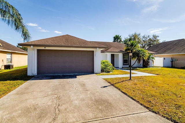 single story home featuring a garage, a front yard, and central AC unit