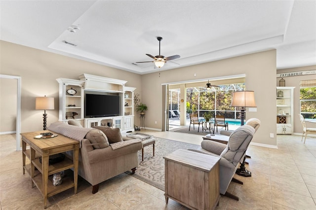 tiled living room with a textured ceiling, a raised ceiling, and ceiling fan