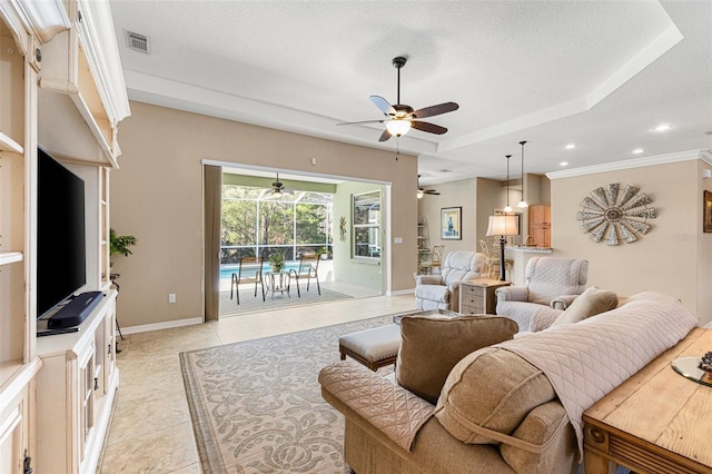 living room featuring a raised ceiling, ceiling fan, light tile patterned floors, and a textured ceiling