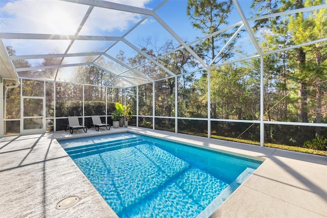 view of swimming pool featuring a patio area and glass enclosure