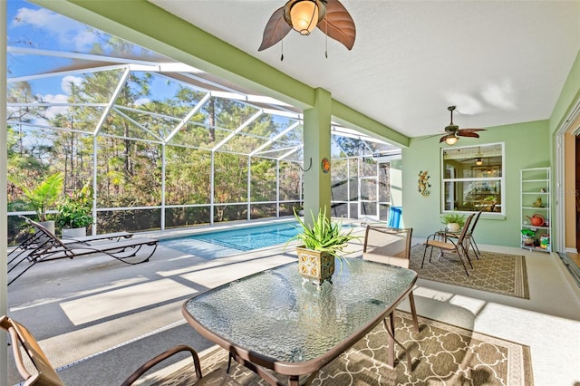 view of pool featuring a patio, ceiling fan, and glass enclosure