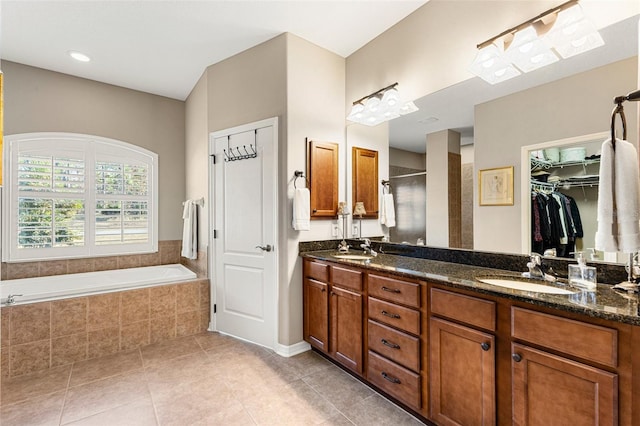 bathroom featuring tile patterned floors, vanity, and shower with separate bathtub