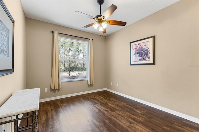 empty room featuring dark wood-type flooring and ceiling fan