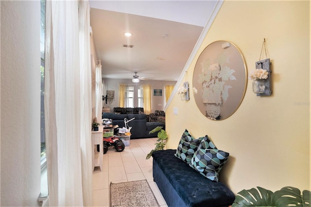 tiled living room featuring crown molding and ceiling fan