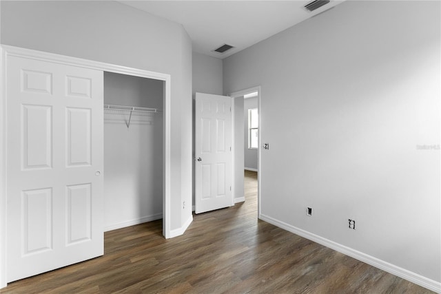 unfurnished bedroom featuring dark hardwood / wood-style floors and a closet