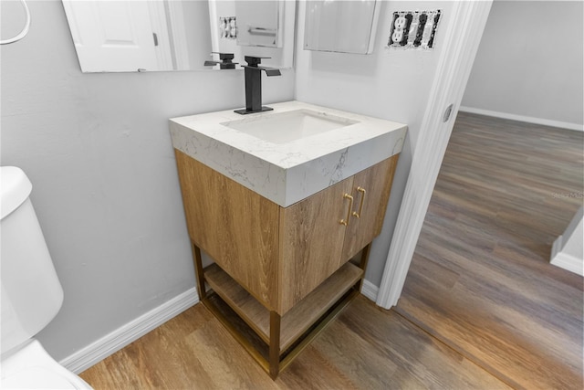 bathroom featuring vanity, hardwood / wood-style floors, and toilet