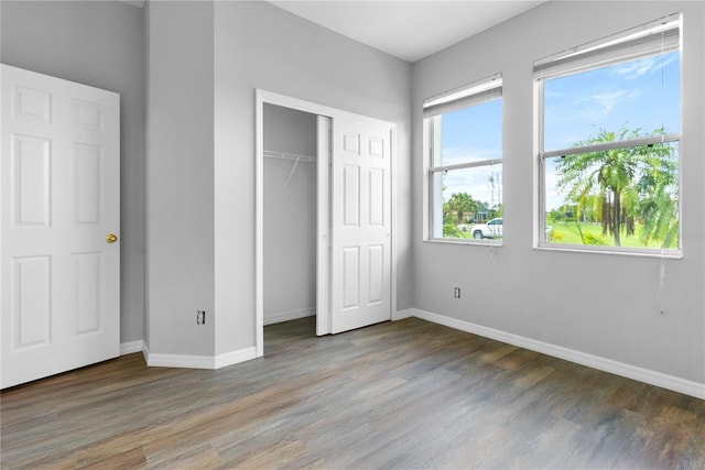 unfurnished bedroom featuring hardwood / wood-style floors and a closet