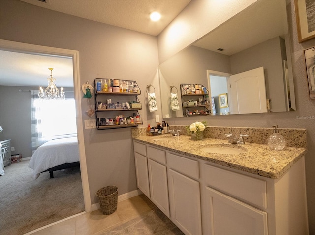 bathroom with vanity, a notable chandelier, and tile patterned floors