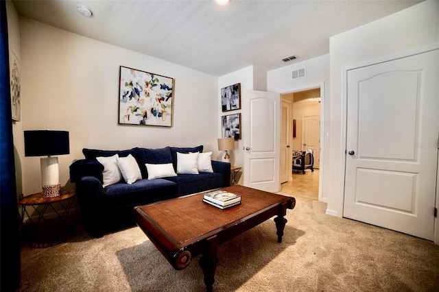 carpeted living room featuring a textured ceiling