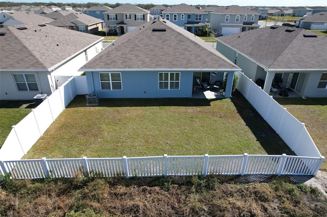 rear view of house featuring cooling unit, a lawn, and a patio