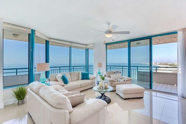 tiled living room featuring a water view, a wall of windows, and ceiling fan