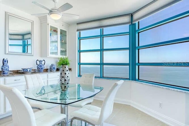 tiled dining space with ceiling fan