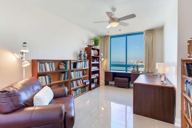 home office featuring ceiling fan, floor to ceiling windows, and light tile patterned floors