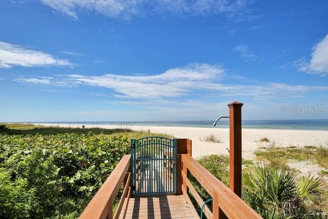 view of home's community with a water view and a beach view