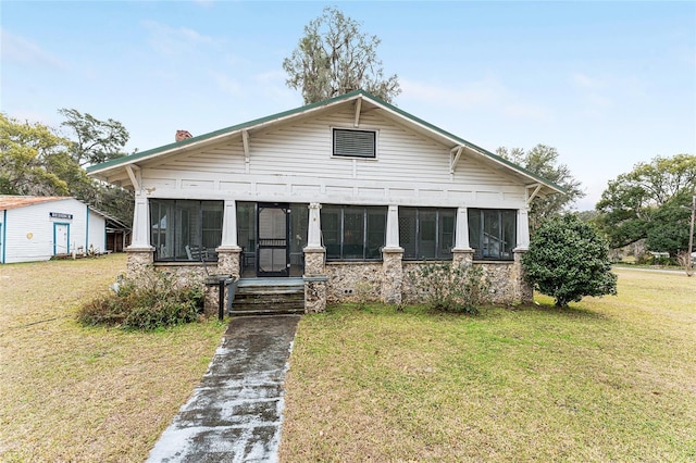 view of front of property with a sunroom and a front yard