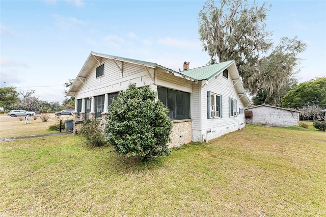 view of side of property with a sunroom and a yard