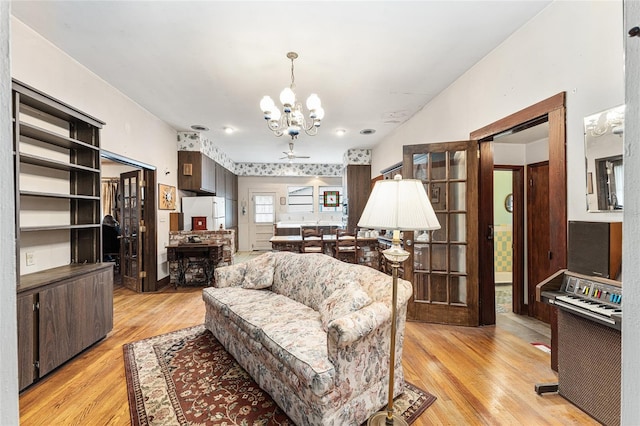 living room with an inviting chandelier and light wood-type flooring