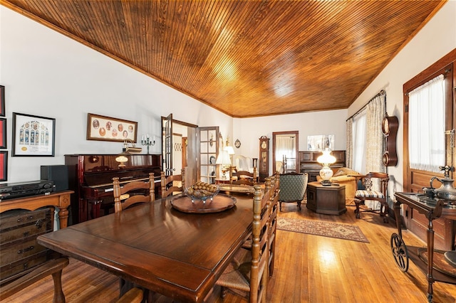 dining room featuring wood ceiling, ornamental molding, and light hardwood / wood-style floors