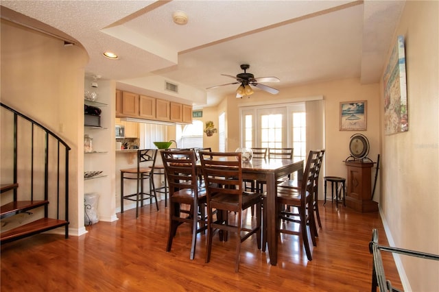 dining space featuring dark hardwood / wood-style flooring, a textured ceiling, and ceiling fan