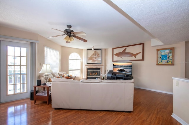 living room featuring hardwood / wood-style floors, a textured ceiling, and ceiling fan