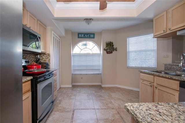 kitchen featuring sink, backsplash, stainless steel appliances, light stone countertops, and light brown cabinets