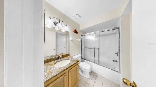 bathroom with toilet, tile patterned flooring, vanity, and bath / shower combo with glass door