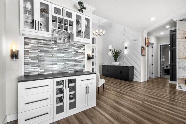 kitchen with dark hardwood / wood-style floors, pendant lighting, white cabinets, decorative backsplash, and ornamental molding