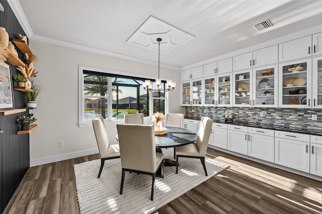 dining area featuring ornamental molding, dark hardwood / wood-style floors, and a chandelier